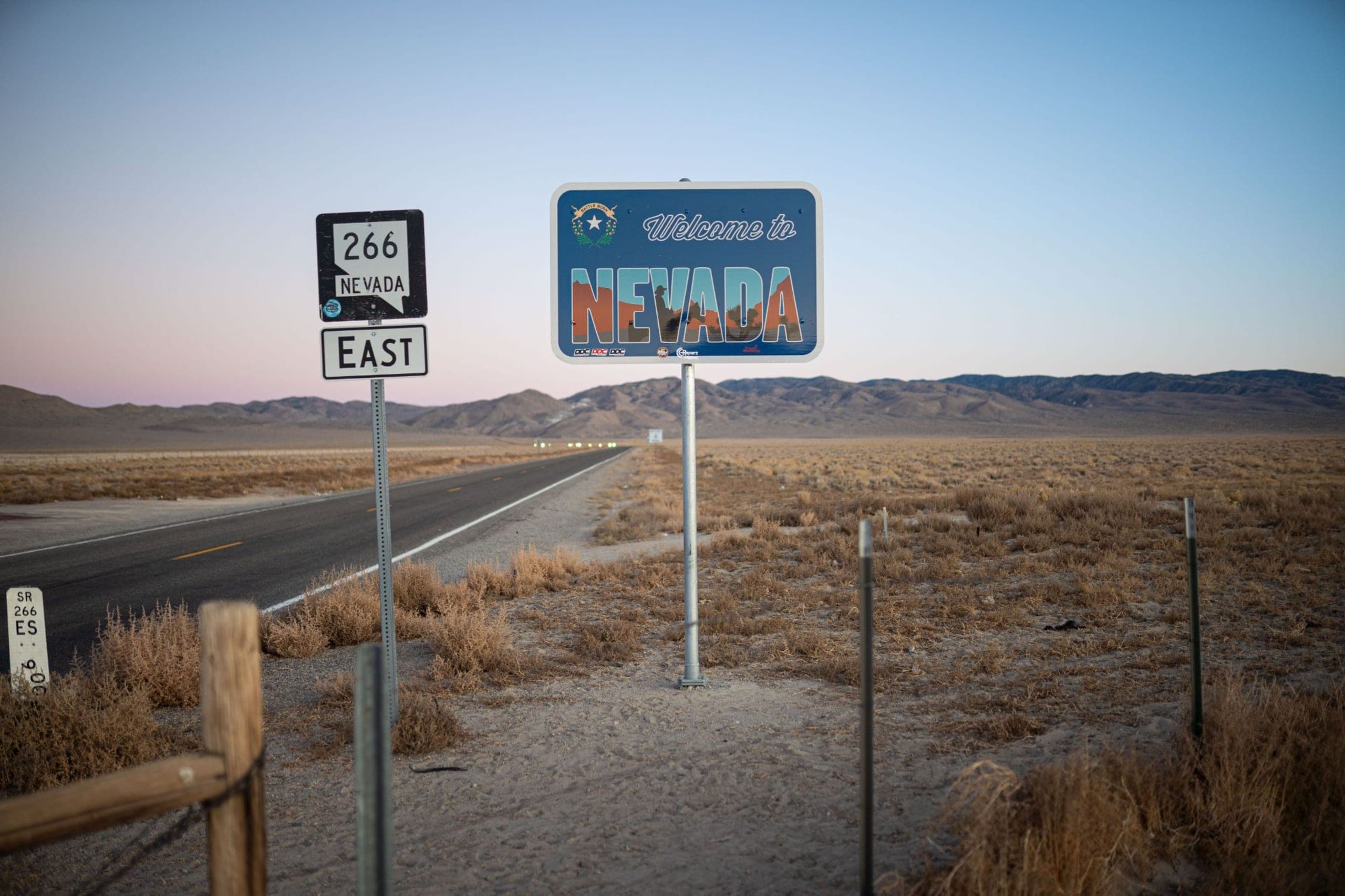 A Welcome to Nevada sign on a desert highway