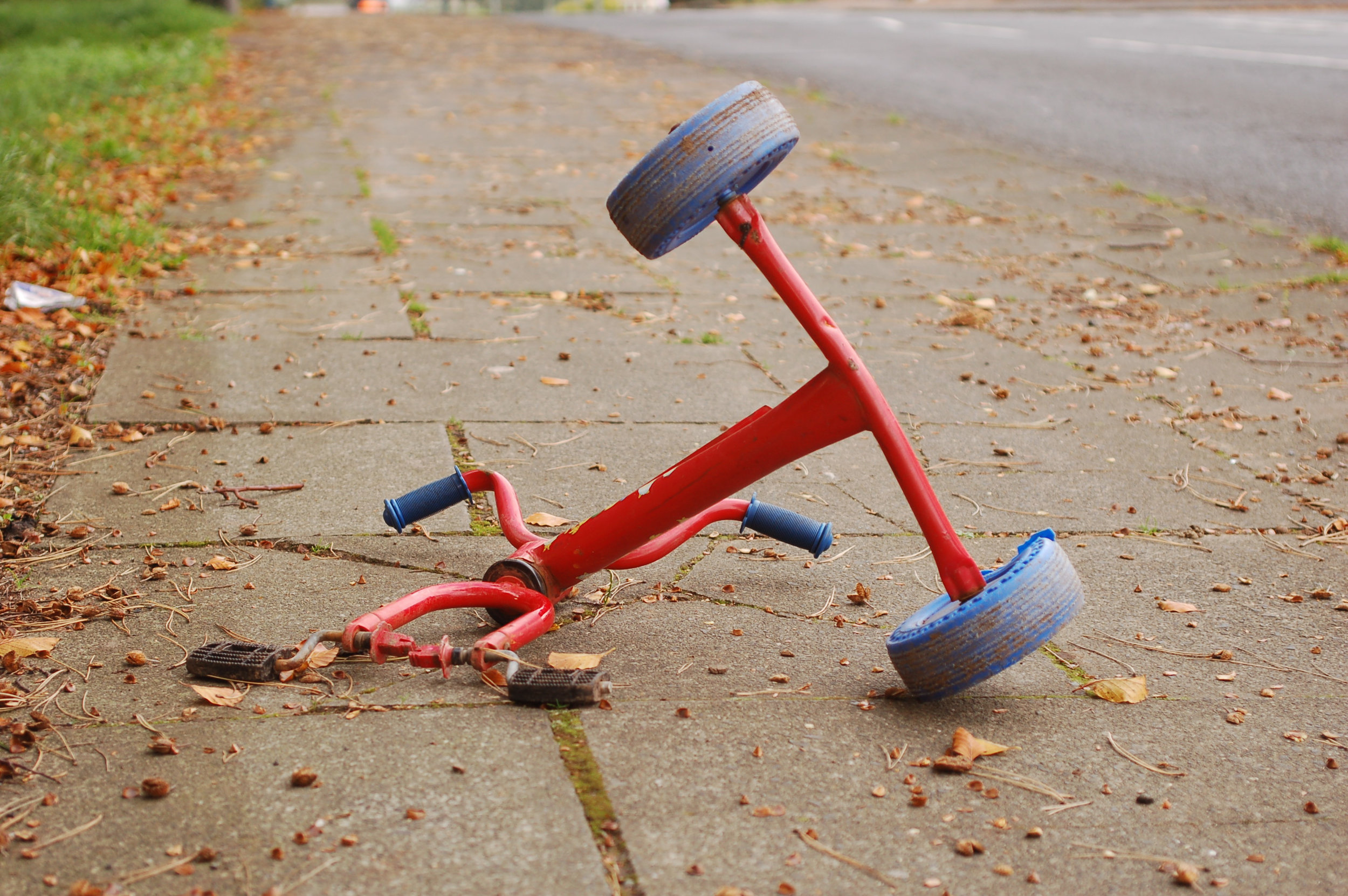 An image of a red tricycle placed on the ground. Legal aid from a product defect attorney may be necessary.