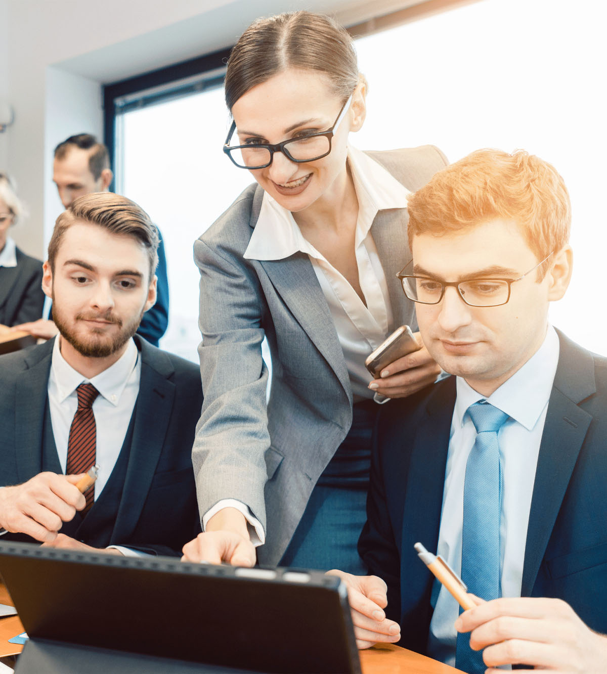 A group of working professional looking at a laptop